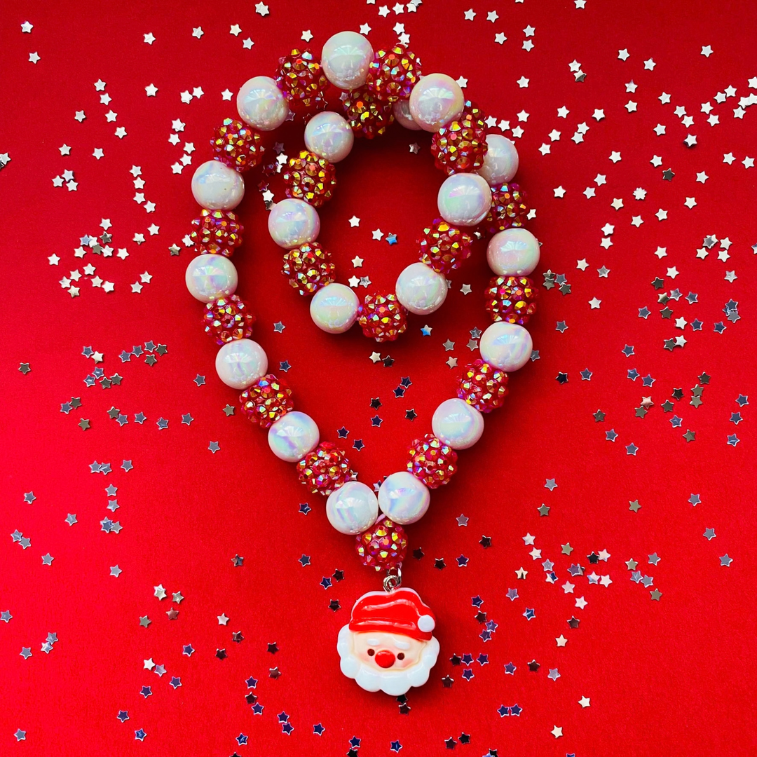 A doubled over beaded Christmas necklace featuring white iridescent beads, red beads covered in small gold rhinestones, and a Santa Claus face charm.