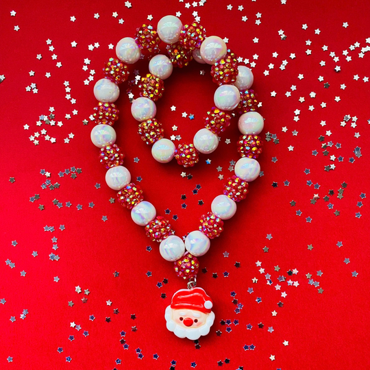 A doubled over beaded Christmas necklace featuring white iridescent beads, red beads covered in small gold rhinestones, and a Santa Claus face charm.