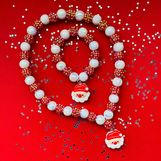 A Christmas-themed beaded necklace and matching bracelet Features white iridescent beads, red spacer beads, and two white Santa Claus charms.