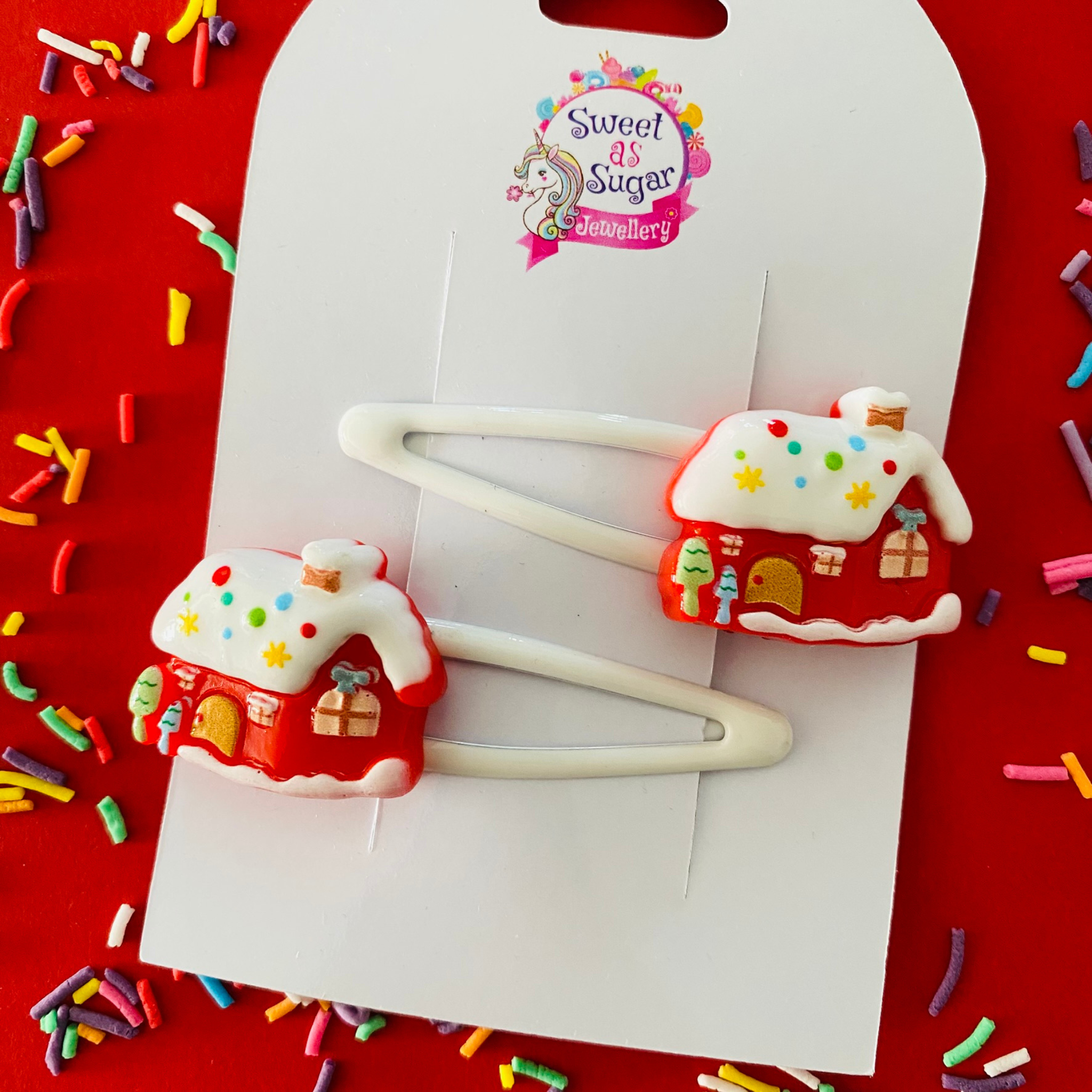 Two white hair clips with Santa's Workshop charms.
