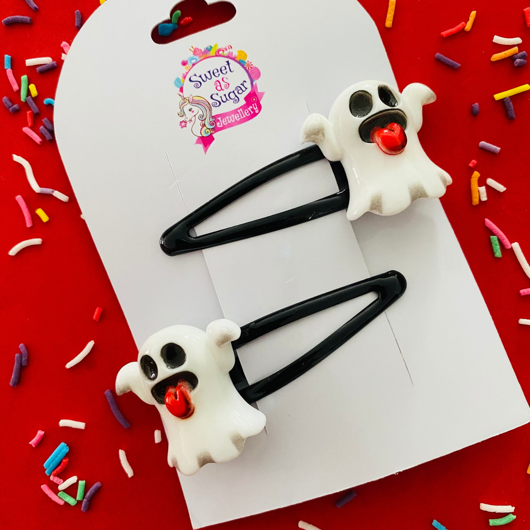 A pair of black hair clips featuring a white ghost with red tongue charm.