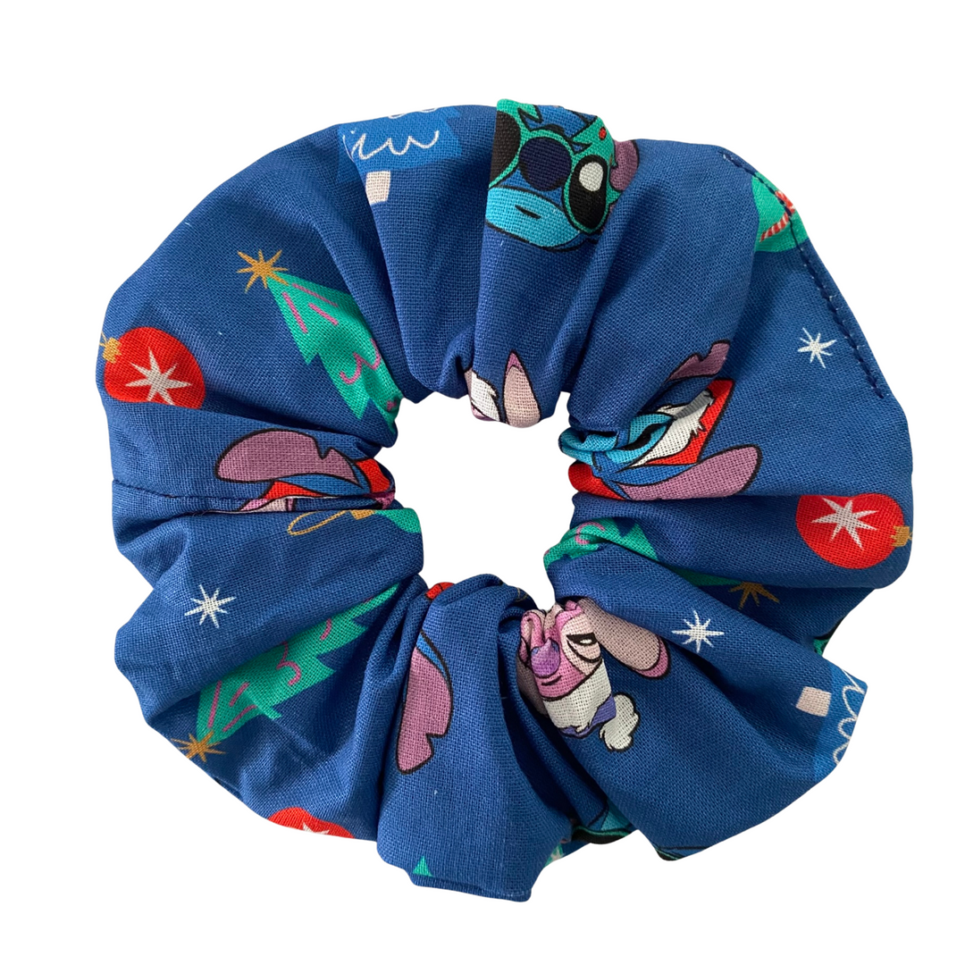 Blue scrunchie with colorful cartoon character pattern on a white background.
