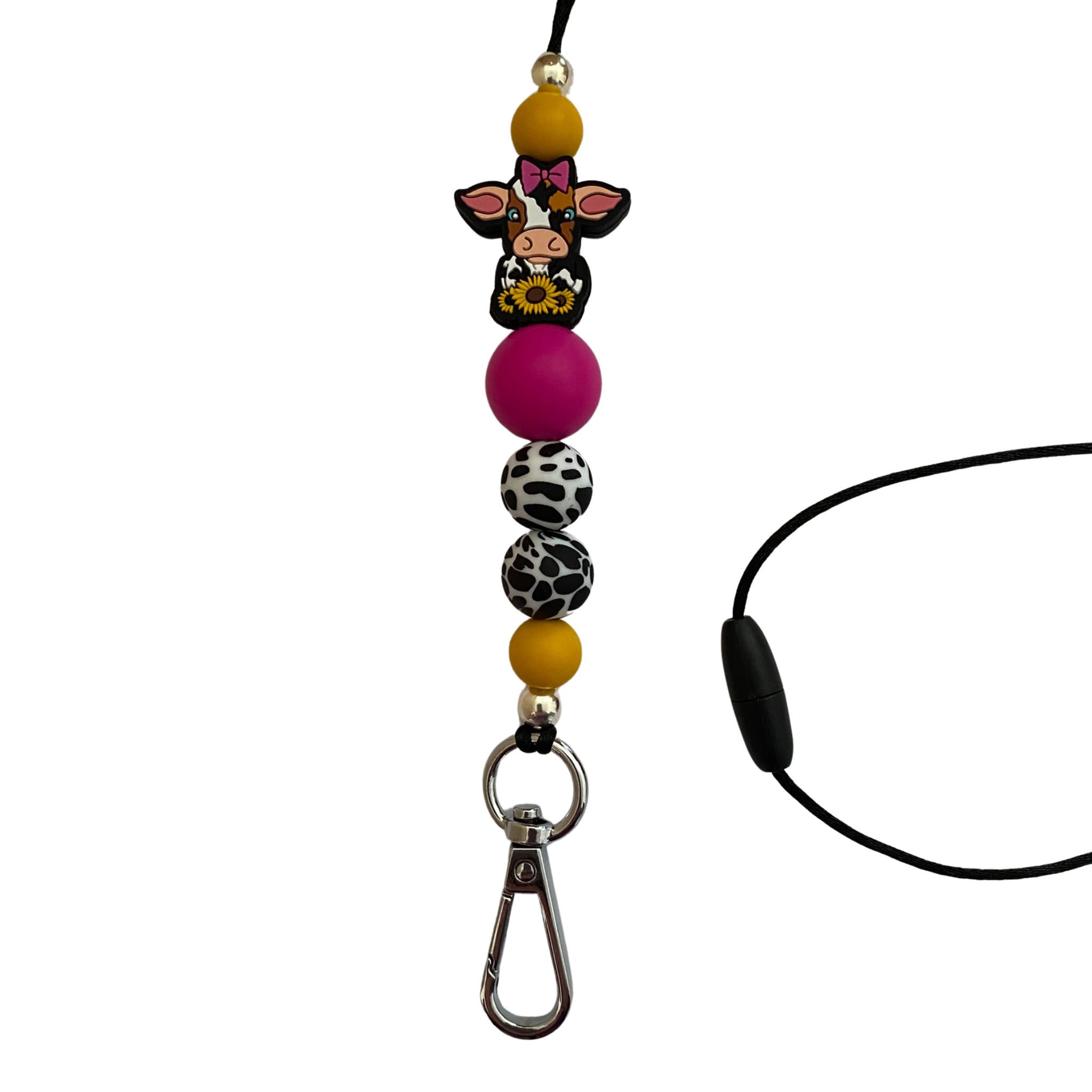 A 60cm lanyard fitted with a safety break away clasp and a cow with a pink bow and sunflowers silicone bead and other coloured round silicone beads.