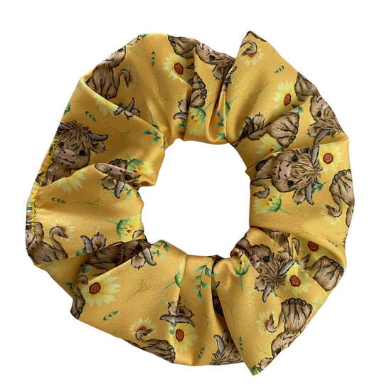 Yellow scrunchie with Highland cow pattern on a white background.