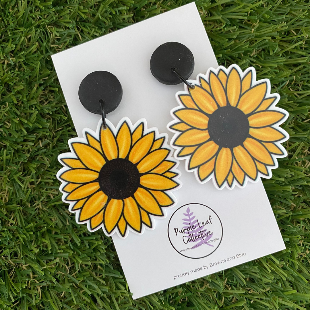 Sunflower shaped dangle arrings set on black clay tops.
