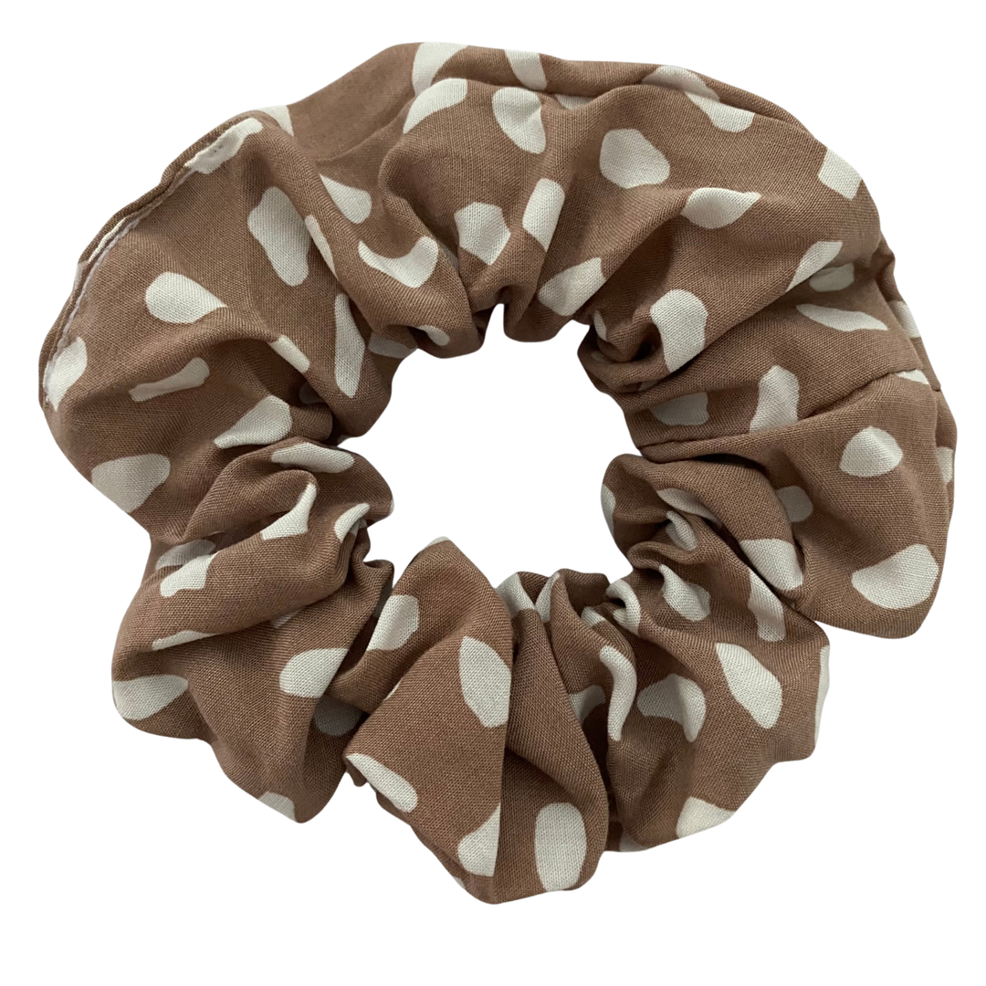 Taupe rayon scrunchie featuring a white animal spot pattern on an earth-toned background.