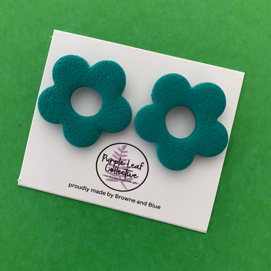 Drop stud earrings with five teal polymer clay flower petals, set on surgical steel posts for comfort and durability.