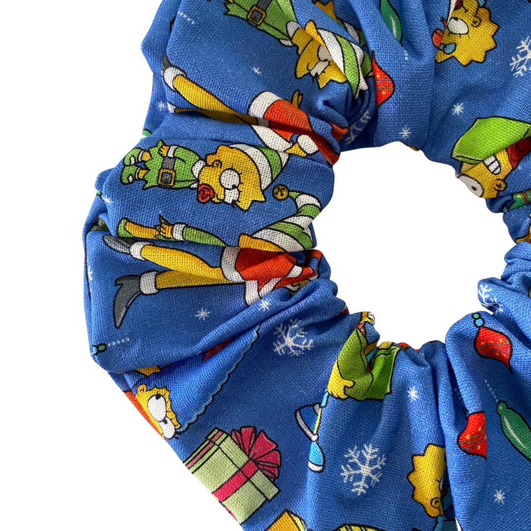 Blue scrunchie with Christmas-themed cartoon character pattern on a white background.