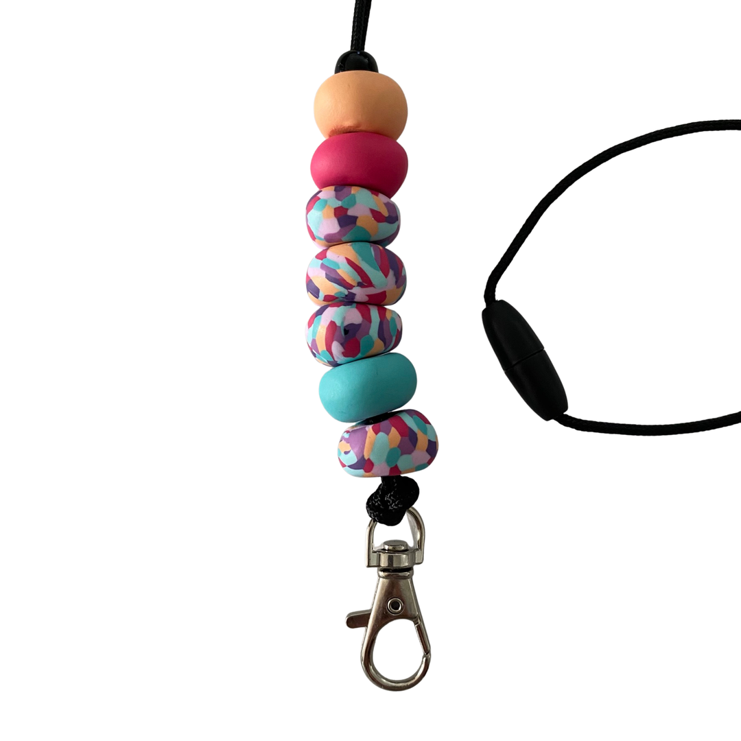 Handmade polymer clay lanyard with seven hand-rolled beads in apricot, raspberry and patterns. Threaded on a nylon cord with a breakaway safety clasp and a silver-plated clip.