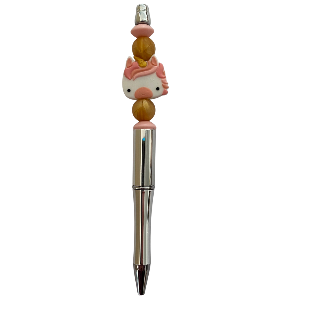 Pen with a unicorn southern peach silicone bead on top on a white background.