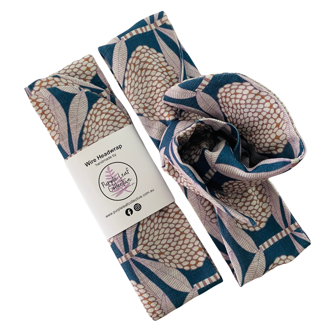 Wire headwrap features a dusty pink waratah repeat pattern on a navy blue background.