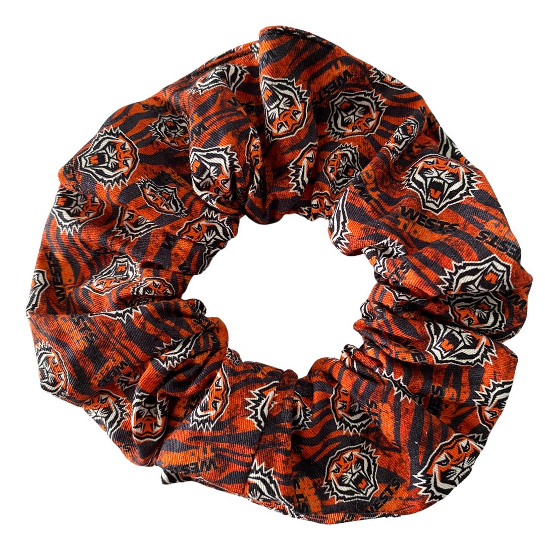 A scrunchie hair tie handmade with cotton woven fabric with images of the Wests Tigers rugby league team.