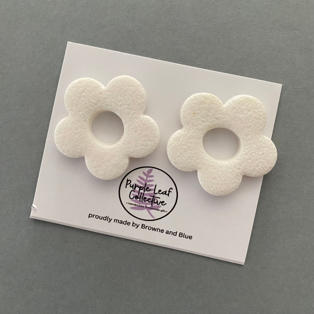 Drop stud earrings with five white polymer clay flower petals, set on surgical steel posts for comfort and durability.