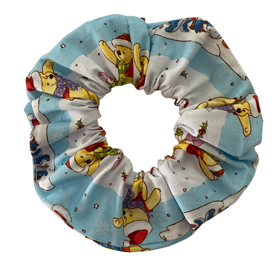 A scrunchie featuring Winnie the Pooh, Tigger, and Piglet on a snowy blue background.