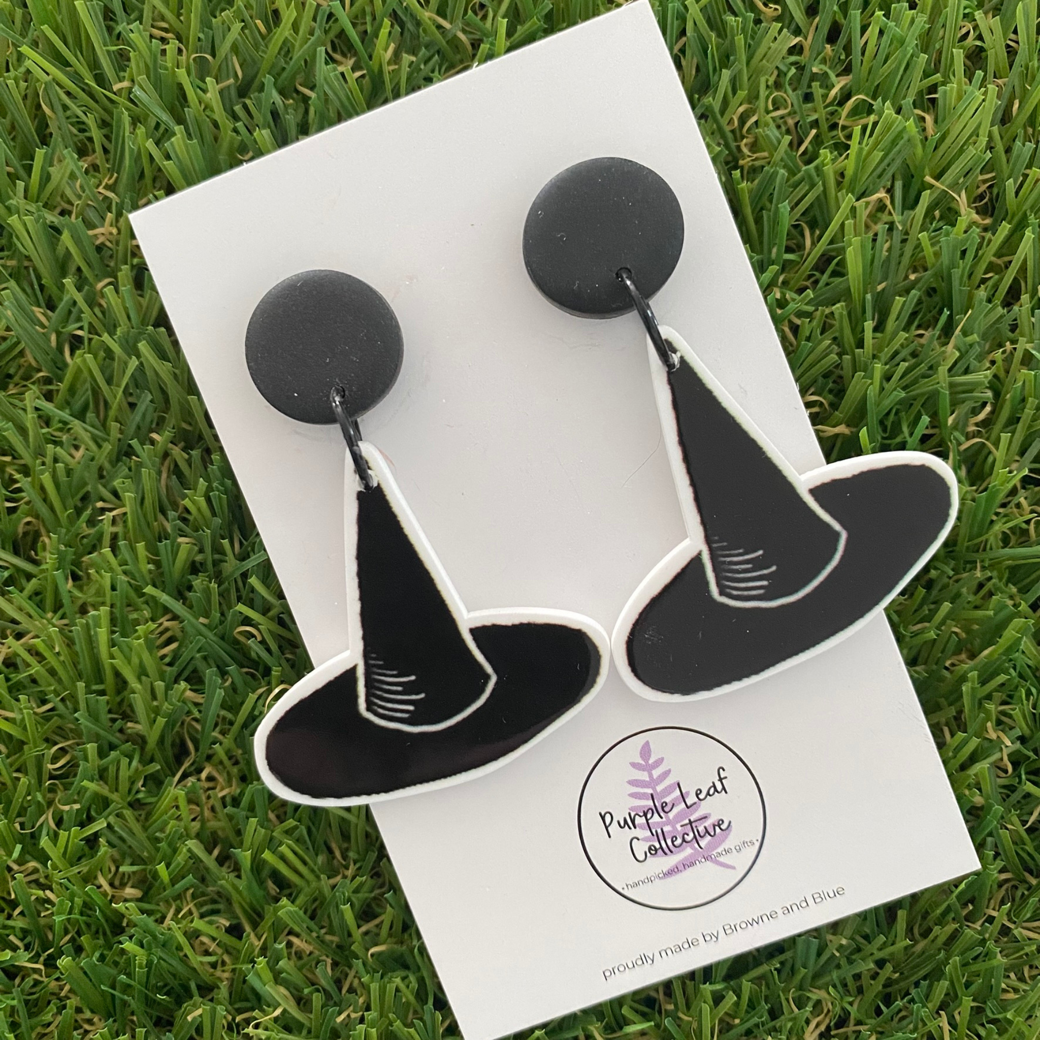 A pair of witch hat dangle earrings featuring a pair of black witch hats on black stud tops.
