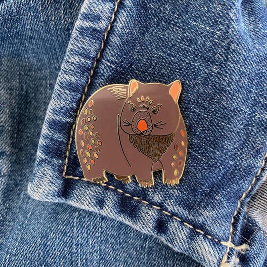 A picture of the Wombat Enamel Pin pictured pinned on a denim jacket.