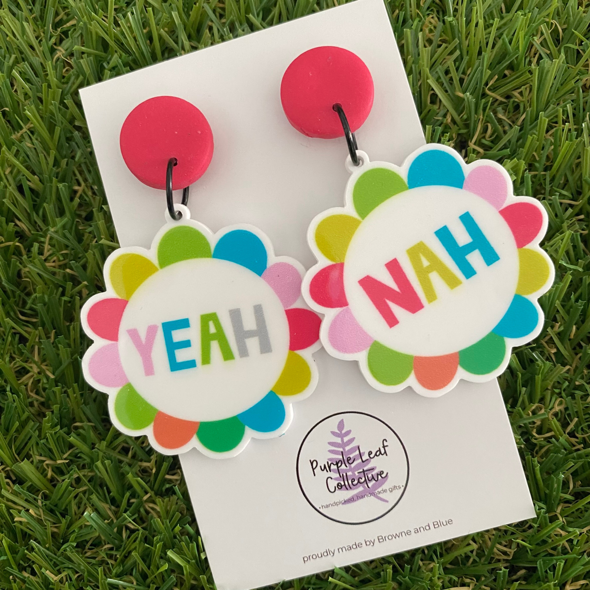 Colorful 'Yeah' and 'Nah' dangle earrings on a backing card.