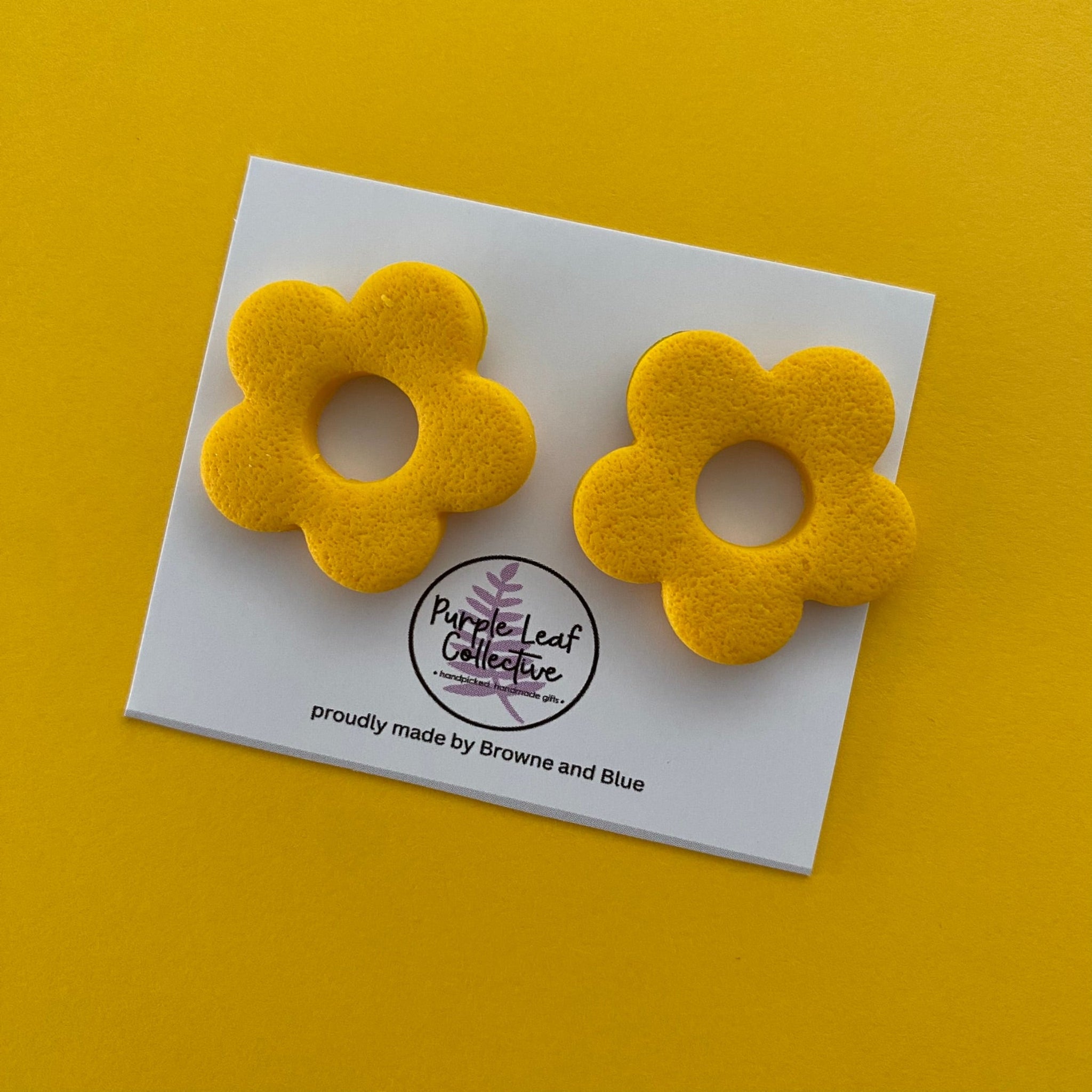 Drop stud earrings with five yellow polymer clay flower petals, set on surgical steel posts for comfort and durability.